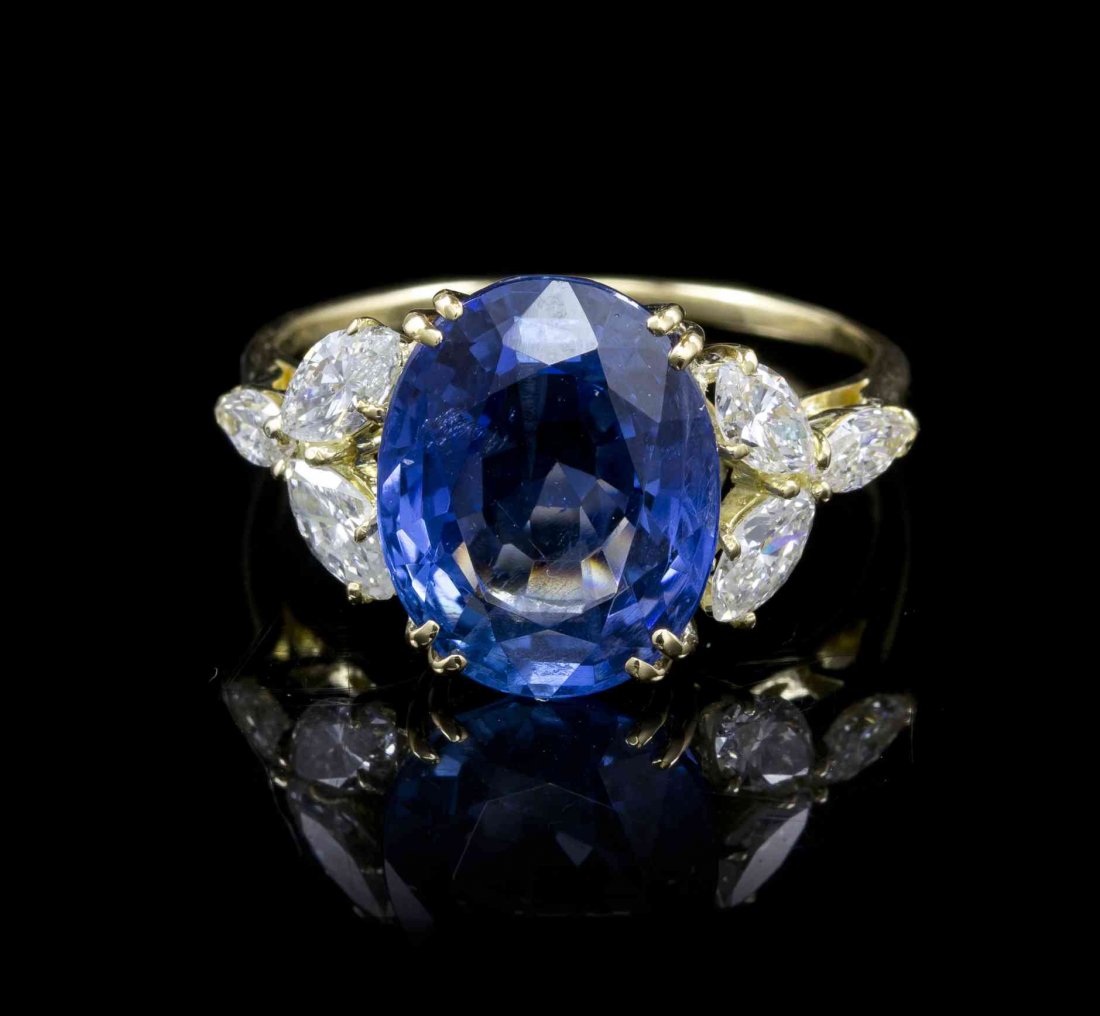 An 18 Karat Yellow Gold, Sapphire and Diamond Ring, Van: An 18 Karat Yellow Gold, Sapphire and Diamond Ring, Van Cleef & Arpels, containing one oval mixed cut sapphire weighing approximately 8.94 carats and six marquise shape brilliant cut diamonds weighing