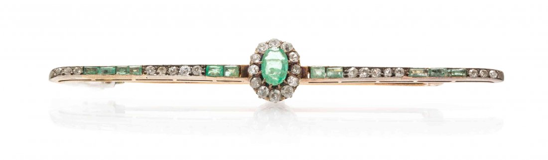 A Victorian Silver Topped Yellow Gold, Emerald and: A Victorian Silver Topped Yellow Gold, Emerald and Diamond Bar Brooch, containing one oval mixed cut emerald measuring approximately 8.76 x 5.80 x 3.11 mm, 11 rectangular step cut emeralds and 28 old 