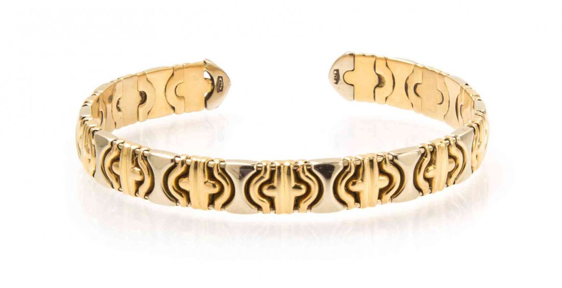 An 18 Karat Yellow and White Gold Bangle Bracelet,: An 18 Karat Yellow and White Gold Bangle Bracelet, flattened Byzantine chain in an open flexible design alternating between yellow and white gold links. Stamp: 750. 12.20 dwts. Property from the Estat