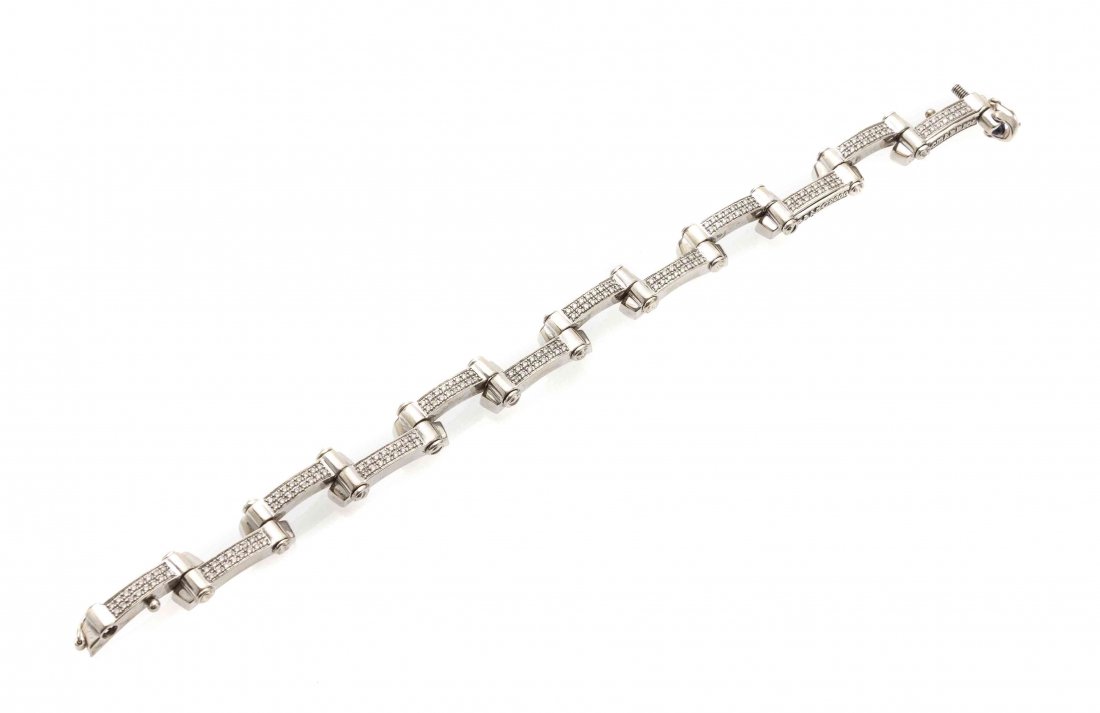 An 18 Karat White Gold, Diamond and Sapphire Bracelet,: An 18 Karat White Gold, Diamond and Sapphire Bracelet, Charriol, containing 192 round brilliant cut diamonds weighing approximately 0.96 carat total and one round cabochon cut sapphire measuring 2.67