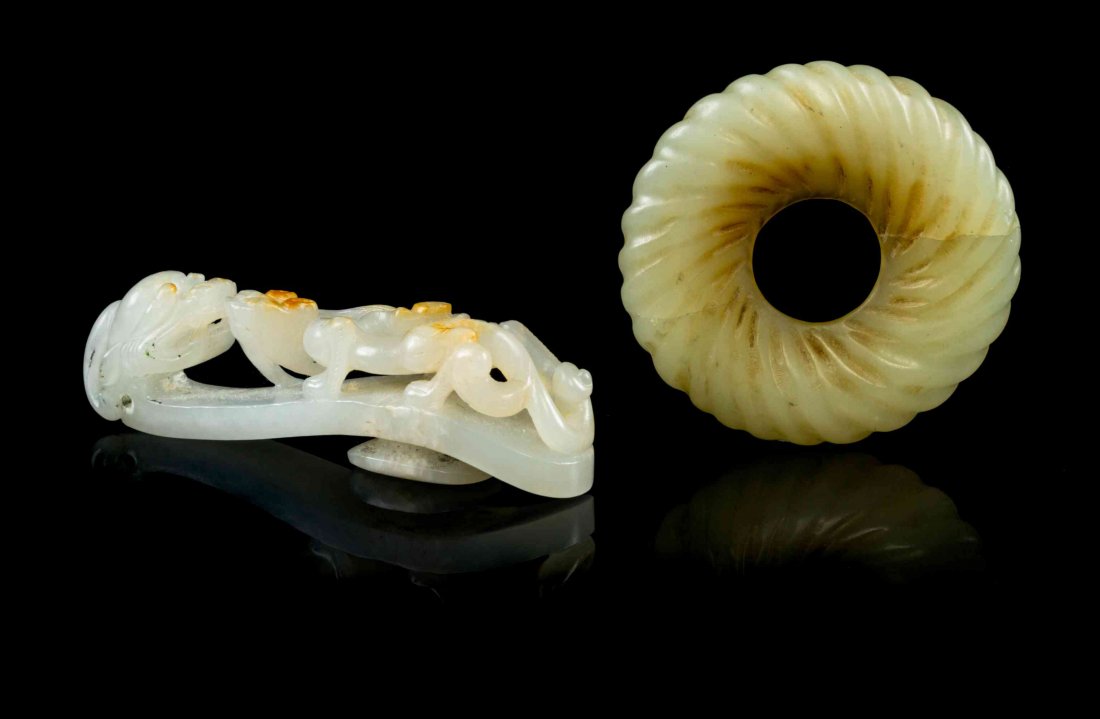 Two Carved Jade Articles, Width of first 3 1/4 inches.: Two Carved Jade Articles, the first a belthook of white stone with orange highlights, depicting a dragon and chilong, the second a celadon jade bi carved with radial design. Width of first 3 1/4 inche