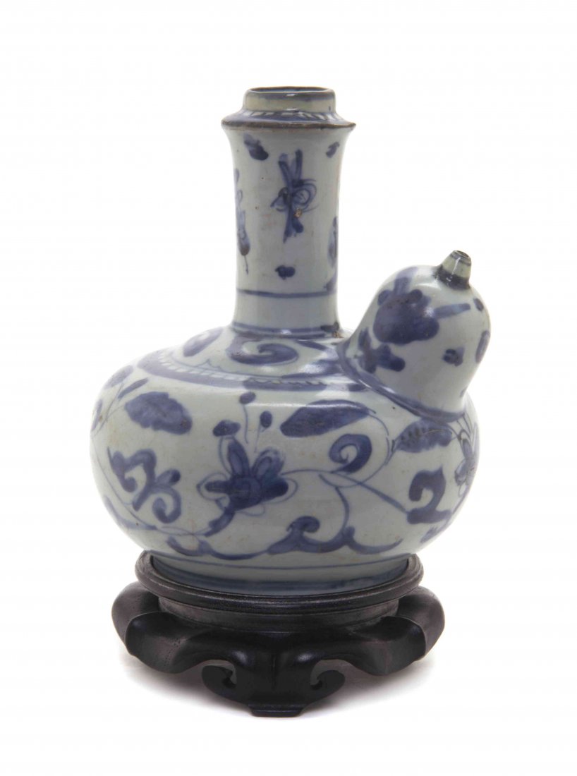 A Blue and White Porcelain Kendi, Height 6 1/8 inches.: A Blue and White Porcelain Kendi, Wanli Period (1572-1620) having scrolling foliate decoration, raised on a hardwood stand. Height 6 1/8 inches. Property from the Collection of James S. Frankenberger,