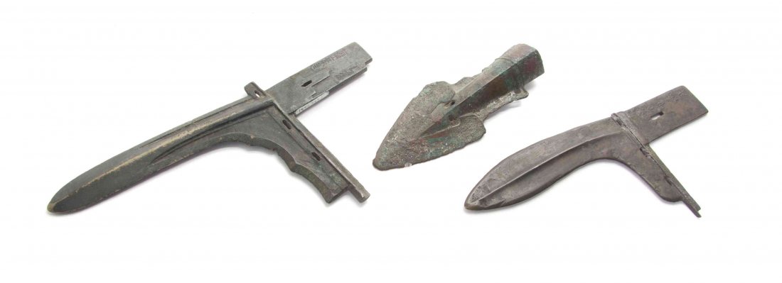 Three Archaistic Chinese Bronze Blades, Width of widest: Three Archaistic Chinese Bronze Blades, Likely Shang/Zhou Dynasty (1600-256 BCE) two of L-shape with curved, tapering blades, and two having inscriptions. Width of widest 10 5/8 inches. Property from 