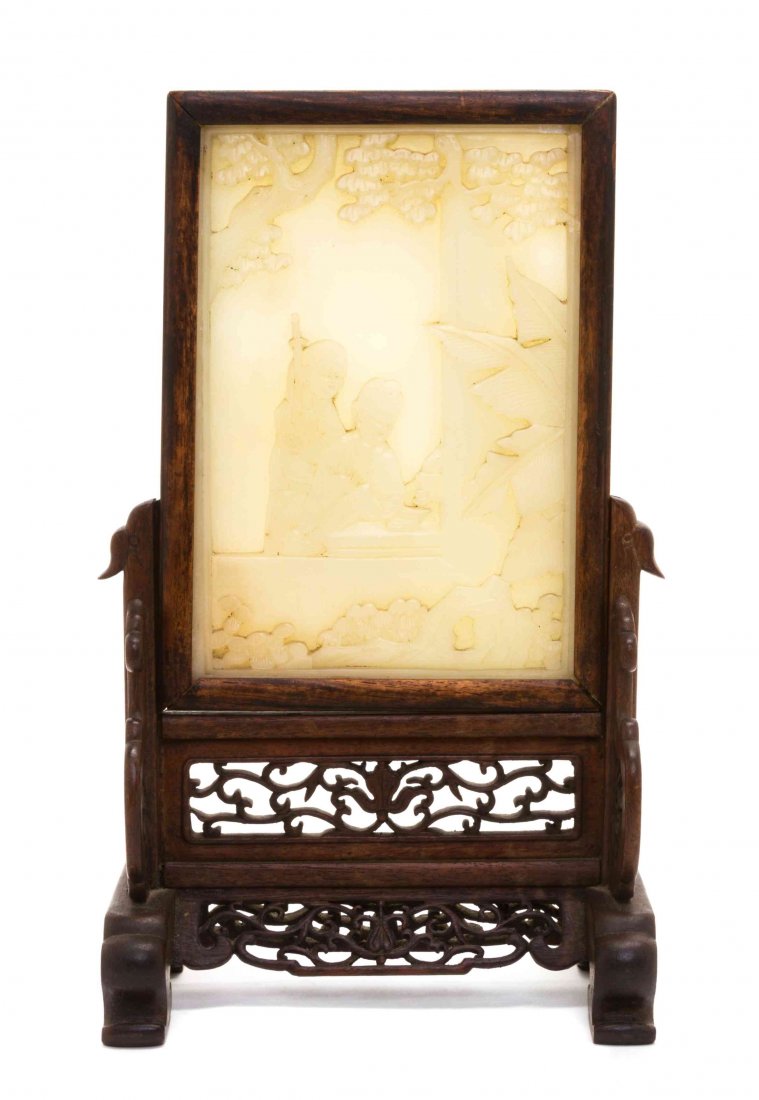 A Chinese Soapstone and Wood Tablescreen, Height: A Chinese Soapstone and Wood Tablescreen, EARLY 20TH CENTURY the rectangular plaque relief carved to depict a figure reading a book with an attendant bearing a sword, seated in a courtyard with tree c