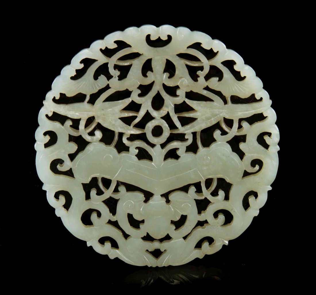 A Pierce Carved Celadon Jade Plaque, Diameter 3 inches.: A Pierce Carved Celadon Jade Plaque, of circular form, depicting a pair of confronting chilong above a bat and chime, with lingzhi and leafy vines. Diameter 3 inches. Condition: In overall good, compl