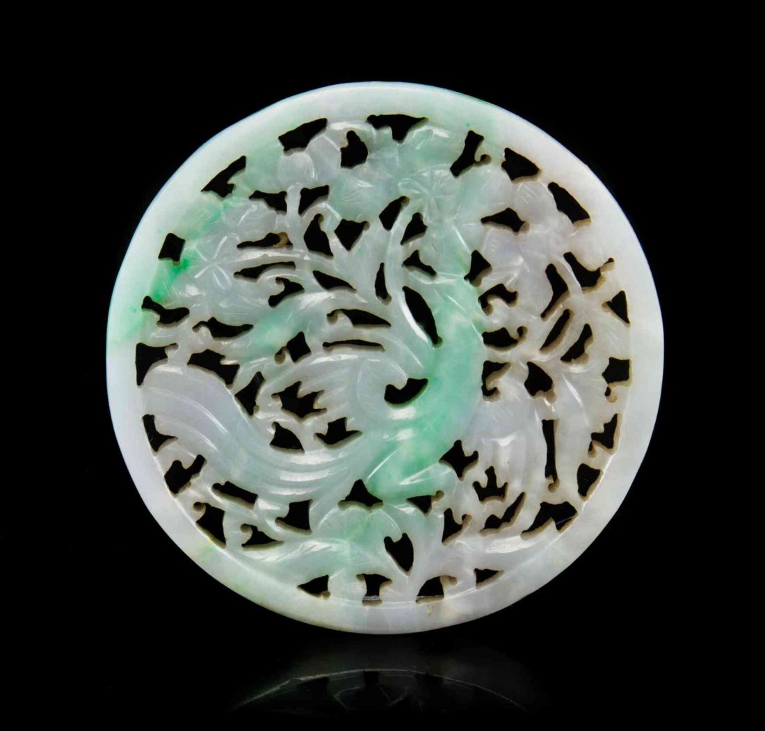 A Pierce Carved Jadeite Plaque, Diameter 2 3/8 inches.: A Pierce Carved Jadeite Plaque, the stone of green and lavender hues, of circular form depicting a phoenix amongst flowering branches. Diameter 2 3/8 inches. Condition: In overall good, complete condi