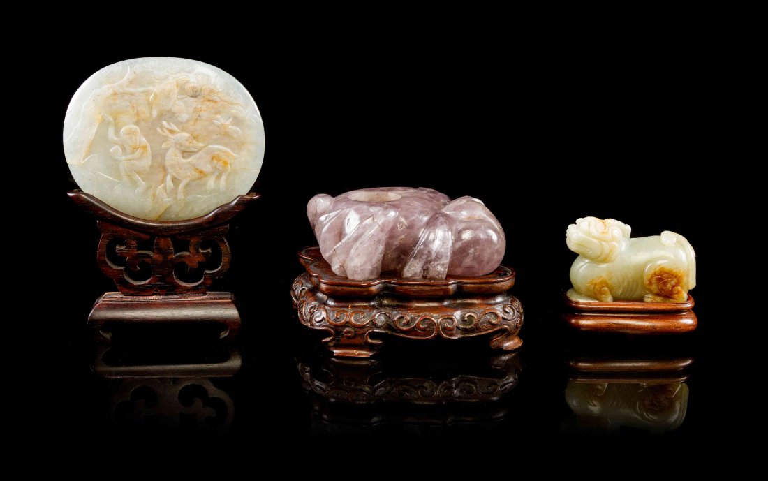 A Group of Chinese Carved Jade Articles, Height of: A Group of Chinese Carved Jade Articles, comprising a white jade ruyi scepter plaque, raised in a hardwood stand, a carved white jade figure of a bixie having russet skin, raised on a fitted wood stan