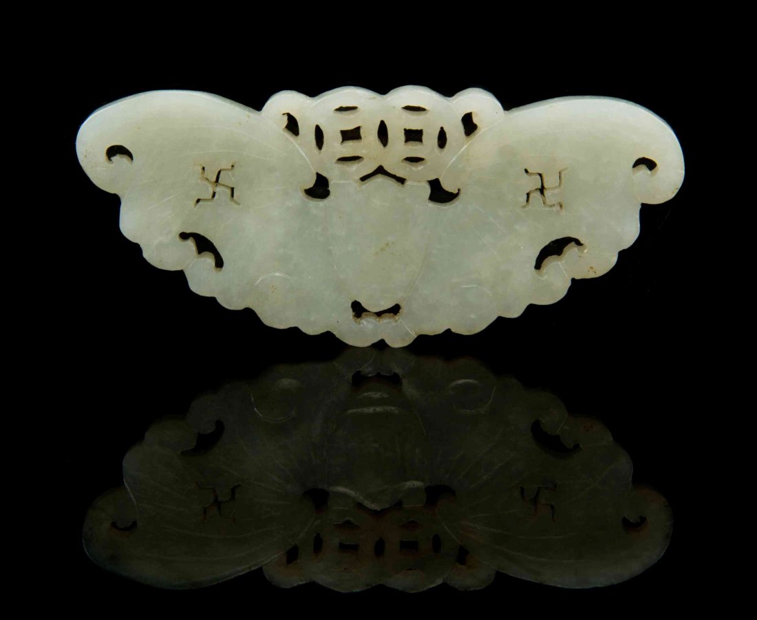 A Pierce Carved Jade Toggle, Width 3 1/2 inches.: A Pierce Carved Jade Toggle, in the form of a butterfly holding two coins, its wings pierced with wan symbols. Width 3 1/2 inches. Condition: Having a few minor chips to the edges. Having surface abra