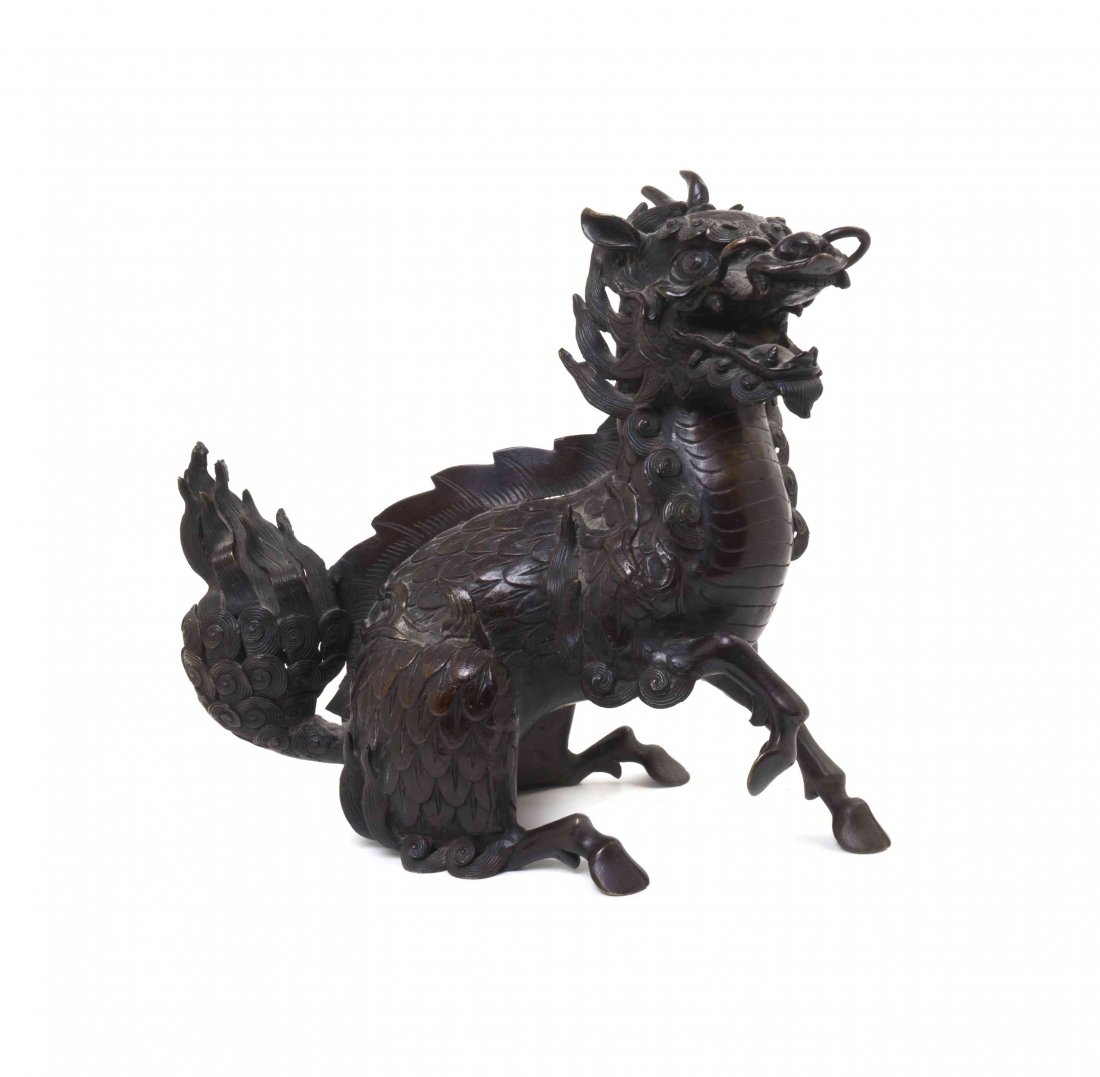 A Japanese Bronze Figure of a Kylin, Height 12 inches.: A Japanese Bronze Figure of a Kylin, the beast depicted with dragon head, fish scaled body, firey mane, lion tail and horse hooves, kneeling on its hind legs and the jaws open as if roaring. Height 12