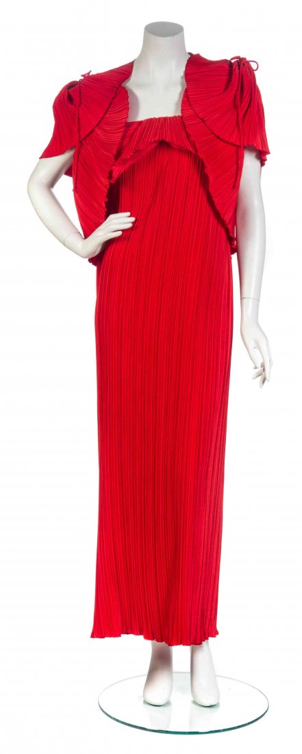 A Mary McFadden Red Pleated Ensemble,: A Mary McFadden Red Pleated Ensemble, comprised of a pleated column gown with camisole straps and folded tier to the bustline, together with a double tiered, rounded bolero with ruched epaulets. Label