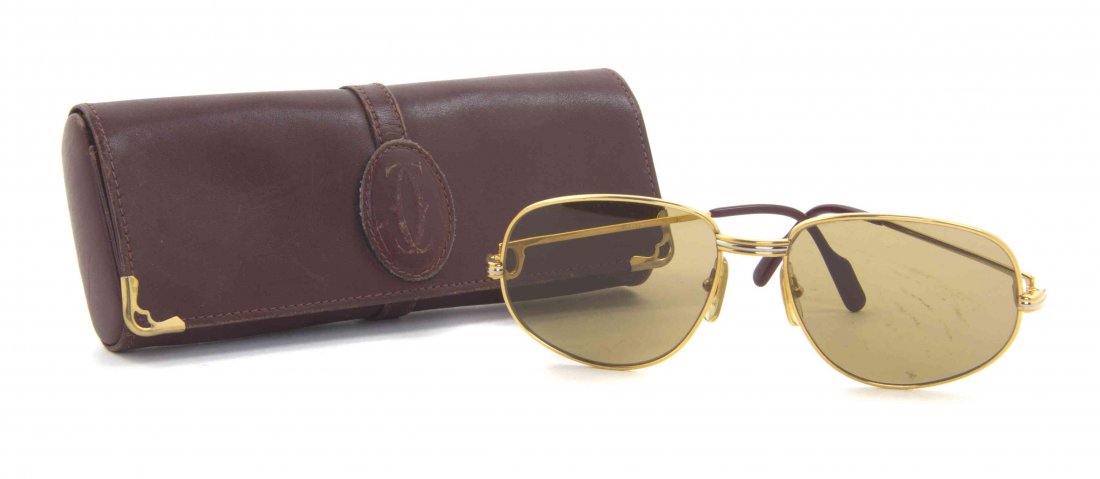 A Pair of Cartier Aviator Sunglasses,: A Pair of Cartier Aviator Sunglasses, goldtone and burgundy frames, with gold lenses. Stamped: Cartier. Condition: Overall good condition. Please note the following: Wear on frames and lens. Wear on o
