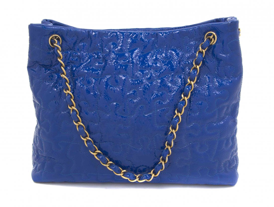 A Chanel Blue Patent Leather Tote, 13 x 10 x 4 inches.: A Chanel Blue Patent Leather Tote, with an all-over puzzle quilting, two interwoven leather and goldtone chain straps, a snap button closure, interior zippered and slip pockets. Stamped: Chanel. 13 x 