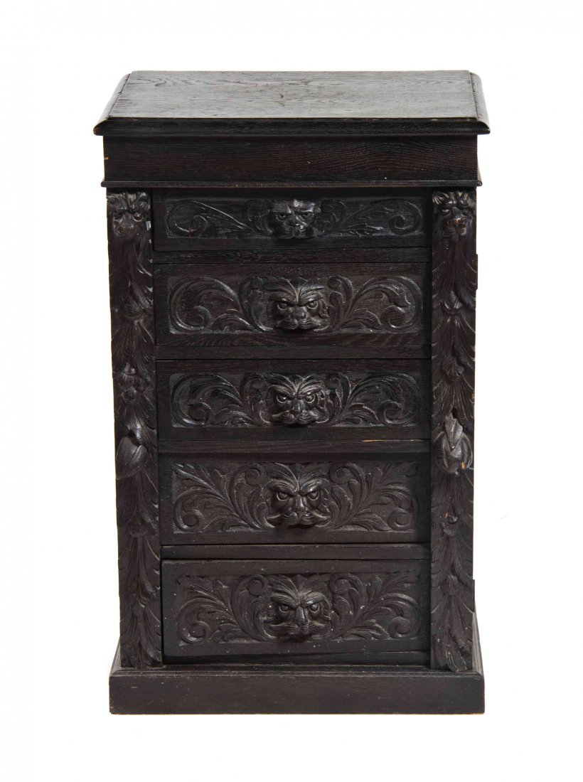 A Continental Oak Wellington Chest, 18TH/19TH CENTURY,: A Continental Oak Wellington Chest, 18TH/19TH CENTURY, each drawer front carved to show foliate scrolls and a grotesque mask. Height 35 x width 22 x depth 15 inches. Property from the Collection of Mi