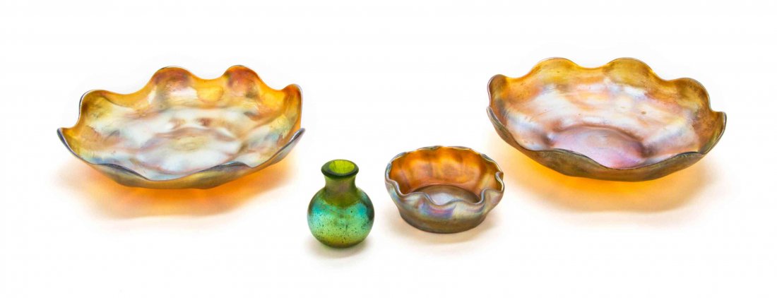 Three Tiffany Studios Gold Favrile Glass Table: Three Tiffany Studios Gold Favrile Glass Table Articles, comprising two underplates and a salt, each with a ruffled rim, signed L.C.T., together with an iridescent diminutive glass vase. Diameter of f