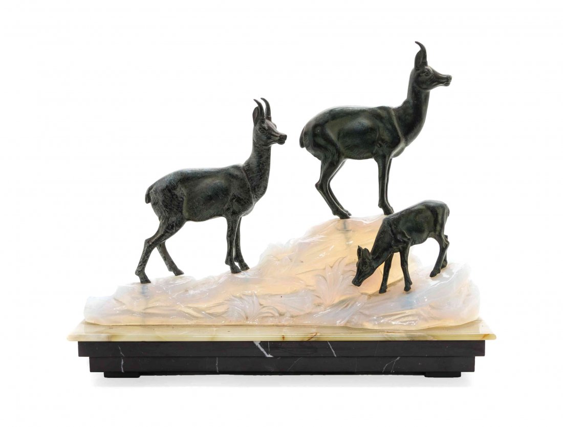 An Art Deco Cast Metal and Molded and Frosted Glass: An Art Deco Cast Metal and Molded and Frosted Glass Figural Lamp, after Fritz Diller, depicting goats on a naturalistic base, further set on an onyx stepped base. Height overall 13 1/2 x width of base