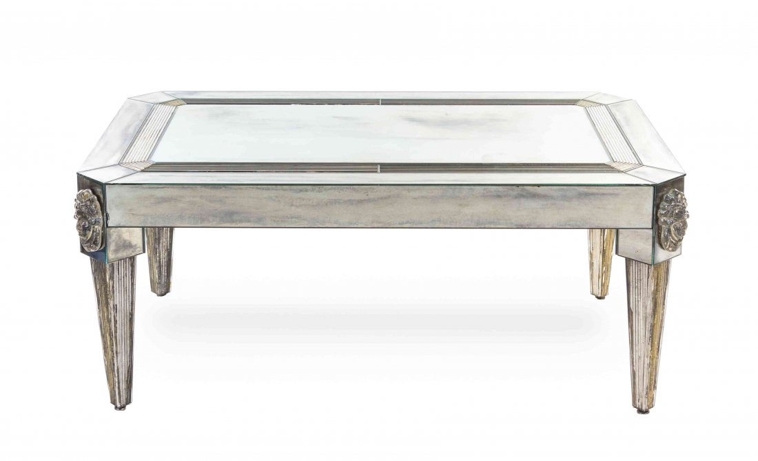 A Mirror Veneered Low Table, likely Italian, Height 20: A Mirror Veneered Low Table, likely Italian, late 20th century, having a rectangular top with canted corners, raised on square tapering legs surmounted with applied masks. Height 20 x width 48 1/4 x d