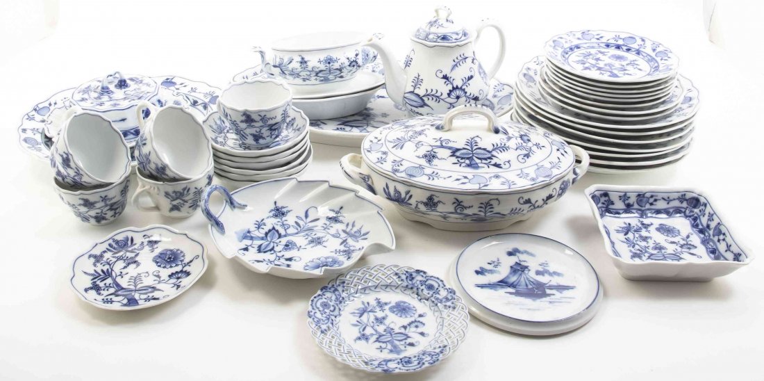 A German Porcelain Partial Dinner Service, Width of: A German Porcelain Partial Dinner Service, in theBlue Onion pattern, in the manner of Meissen, comprising cups, saucers, luncheon plates, a teapot, serving platters, a butter dish, a sauce boat and ot