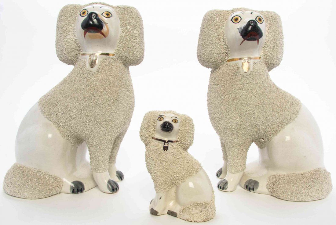 Three Staffordshire Earthenware Dogs, Height of tallest: Three Staffordshire Earthenware Dogs, comprising a pair of poodles and a smaller example. Height of tallest 9 1/2 inches.