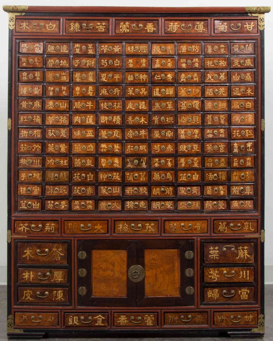 A Korean Apothecary Chest, Height 52 x width 42 x depth: A Korean Apothecary Chest, having brass mounts with pierced wan and coin motifs, with numerous shelves of graduated size marked with the names of herbs, the lower register with double brass doors havi