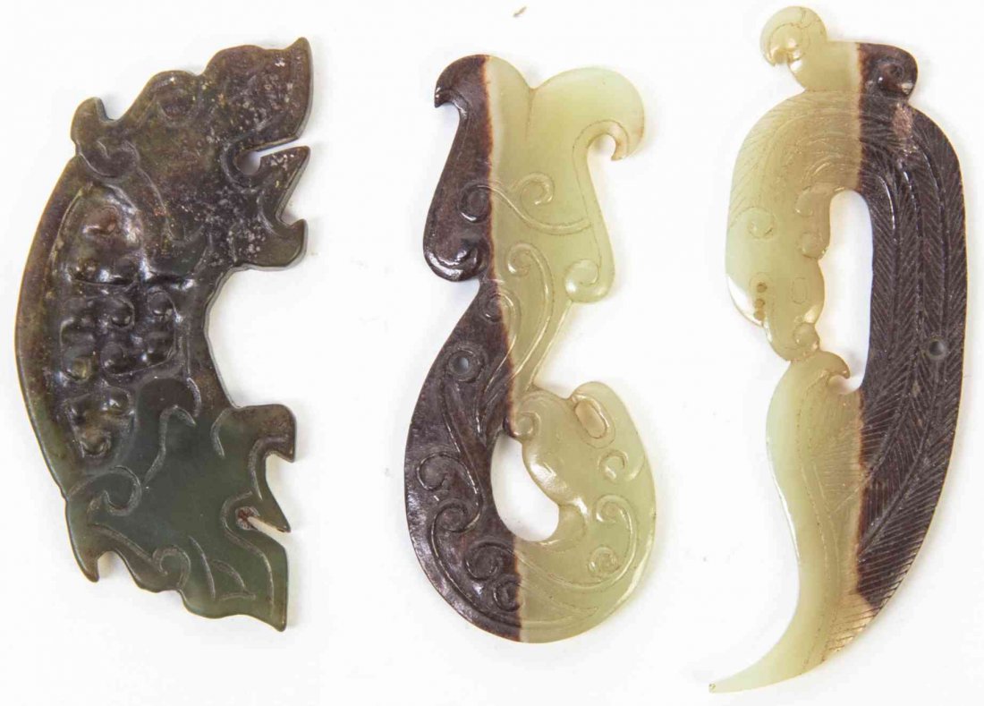 A Group of Three Carved Jade and Hardstone Articles,: A Group of Three Carved Jade and Hardstone Articles, the first a knot pick in celadon and russet hardstone, depicting a coiled chilong, a celadon and russet hardstone toggle with relief carved scrollw