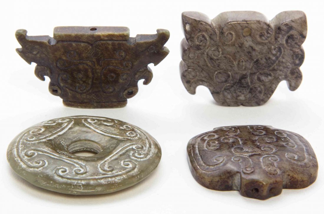 Three Carved Jade Toggles, Width of widest 2 5/8: Three Carved Jade Toggles, each having archaistic relief carved decoration and of mottled russet stones, together with a green hardstone bi. Width of widest 2 5/8 inches. Property from the Estate of A