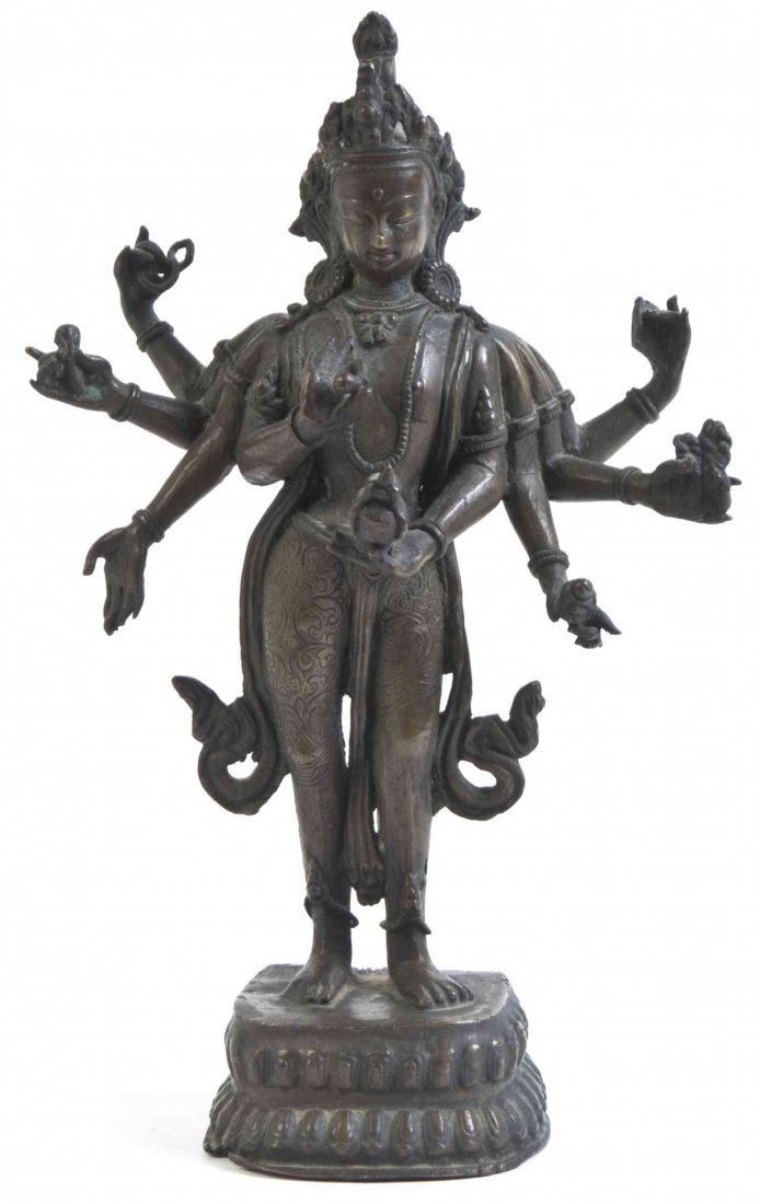 A Tibetan Bronze Figure of a Buddhist Deity, Height 9: A Tibetan Bronze Figure of a Buddhist Deity, the figure having eight arms bearing attributes, raised on a double lotus form base. Height 9 3/4 inches. Property from a Private Collection, Zionsville, I