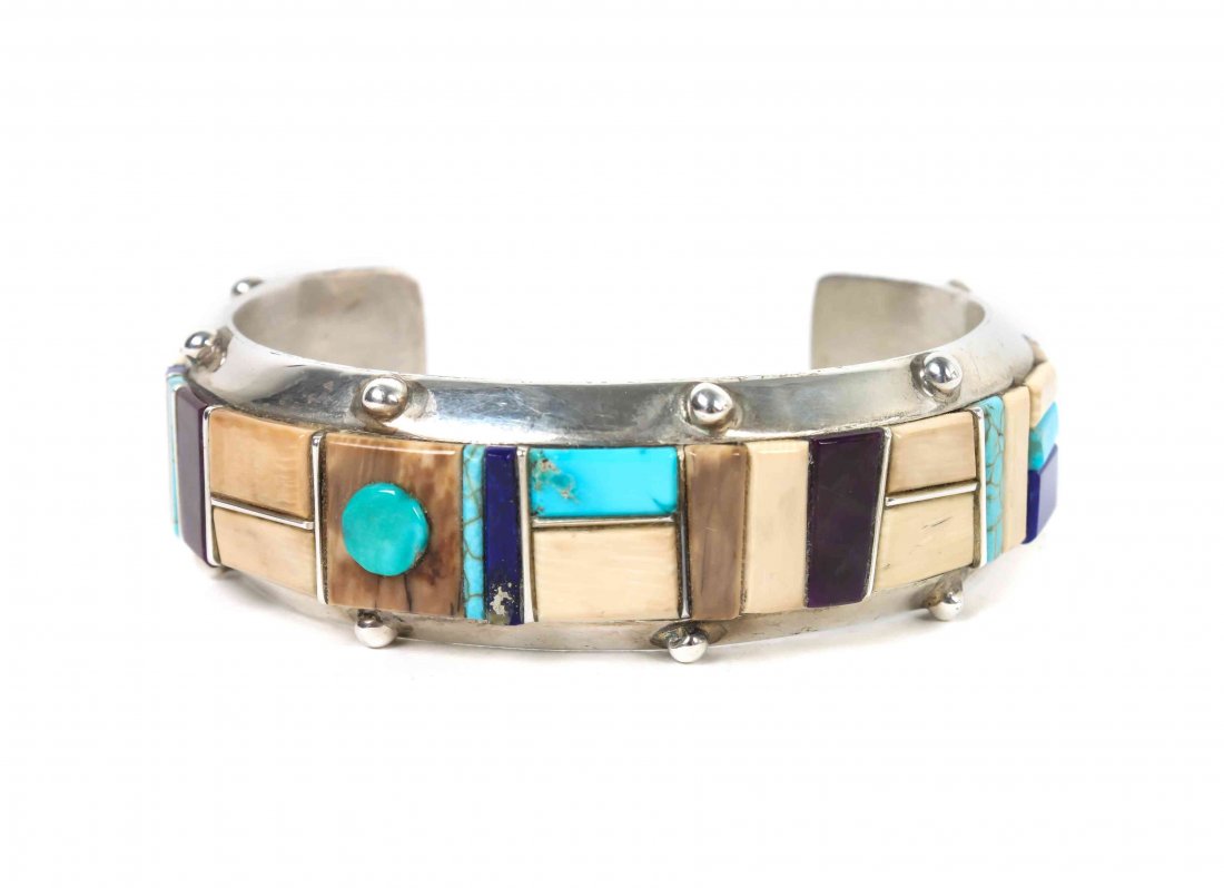 A Hopi Silver Bracelet, Michael Dukepoo, Length 6 7/8x: A Hopi Silver Bracelet, Michael Dukepoo, having a geometric inlay of bone, lapis, sugilite and turquoise on a silver band, signed "Dukepoo." Length 6 7/8x opening 1 1/4 x width 3/4 inches.