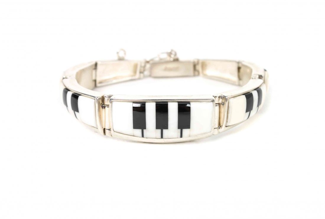 A Navajo Link Bracelet, Calvin Begay, Length 7 x width: A Navajo Link Bracelet, Calvin Begay, having onyx and white buffalo turquoise in piano key design. Length 7 x width 1/2 inches.