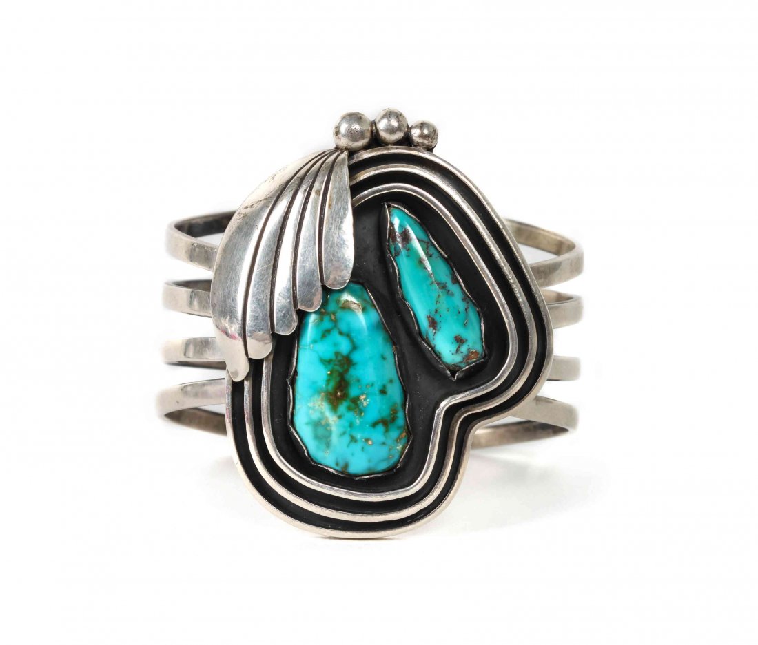 A Navajo Silver and Turquoise Cuff Bracelet, Kee Joe: A Navajo Silver and Turquoise Cuff Bracelet, Kee Joe Benally (b. 1936), having two free form stones surrounded by three shadow boxed rings with leaf decoration on four shanks, signed "W" for Woodard's