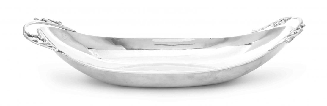 A Mexican Silver Bread Tray, P. Lopez G., Mid 20th: A Mexican Silver Bread Tray P. Lopez G., Mid 20th Century of oval boat form, the ends applied with foliate scroll handles marked on base 23 ozt 4 dwt Length 16 5/8 inches Property from the Estate of M