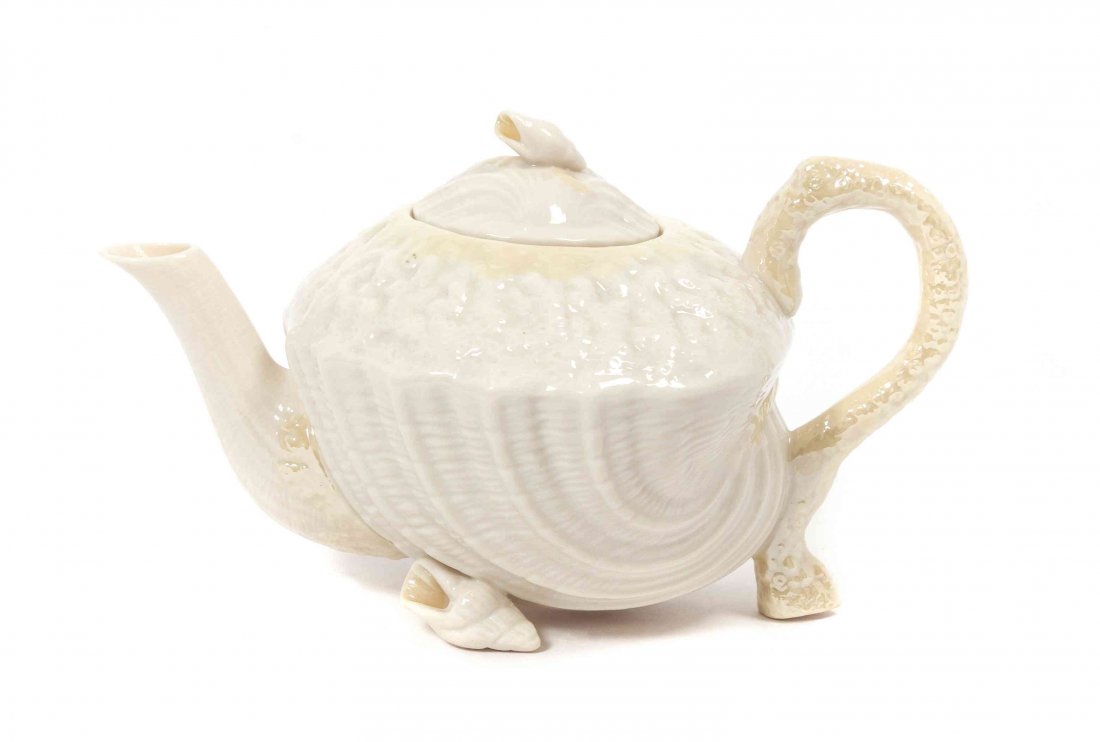 A Belleek Neptune Teapot, Height 6 x width 10 x depth 6: A Belleek Neptune Teapot, having a yellow and cream glaze with seashell finial, resting on seashell feet. Height 6 x width 10 x depth 6 3/4 inches. Condition: In great condition.