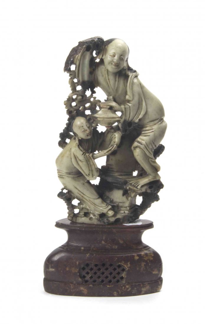 A Chinese Soapstone Carving, Height overall 11 3/4: A Chinese Soapstone Carving, Qing Dynasty, depicting a figure with an attendant, holding a covered bowl. Height overall 11 3/4 inches.