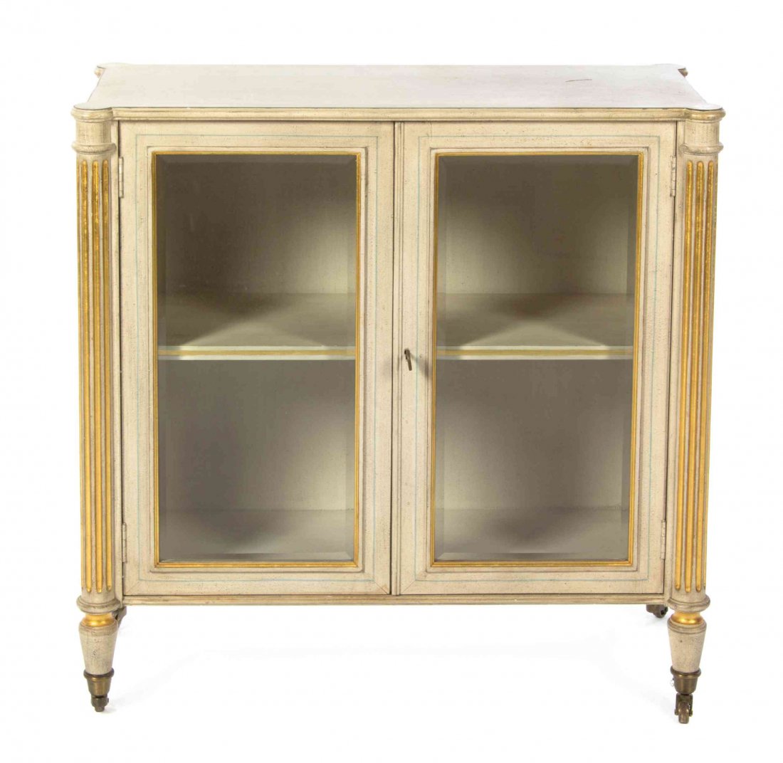 A Louis XVI Style Painted and Parcel Gilt Console: A Louis XVI Style Painted and Parcel Gilt Console Cabinet, having a rectangular galleried top with turret corners over two glazed doors flanked by columns, raised on tapering legs ending in casters. H