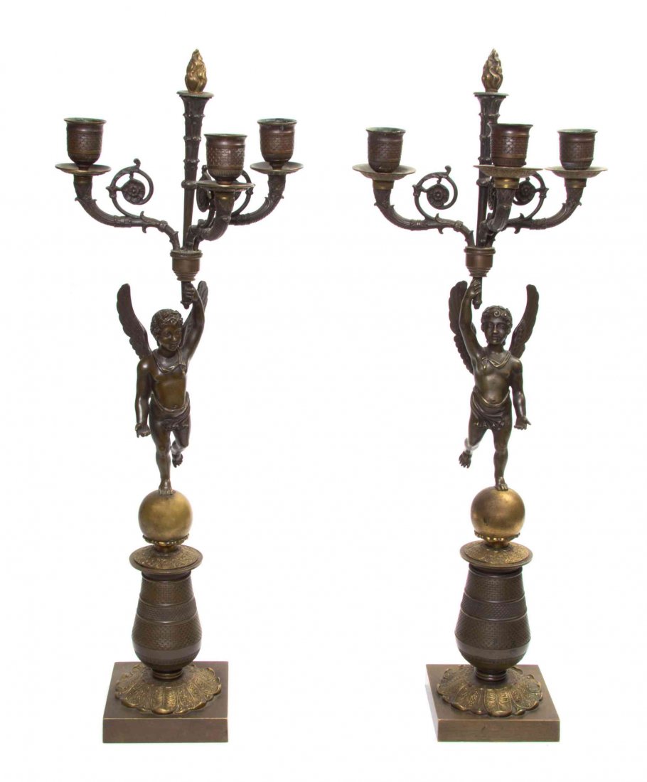 A Pair of Empire Style Gilt and Patinated Metal Three-L: A Pair of Empire Style Gilt and Patinated Metal Three-Light Candelabrum, each in the form of a winged figure seated on a sphere and supporting the lighting elements. Height 21 2/3 inches.