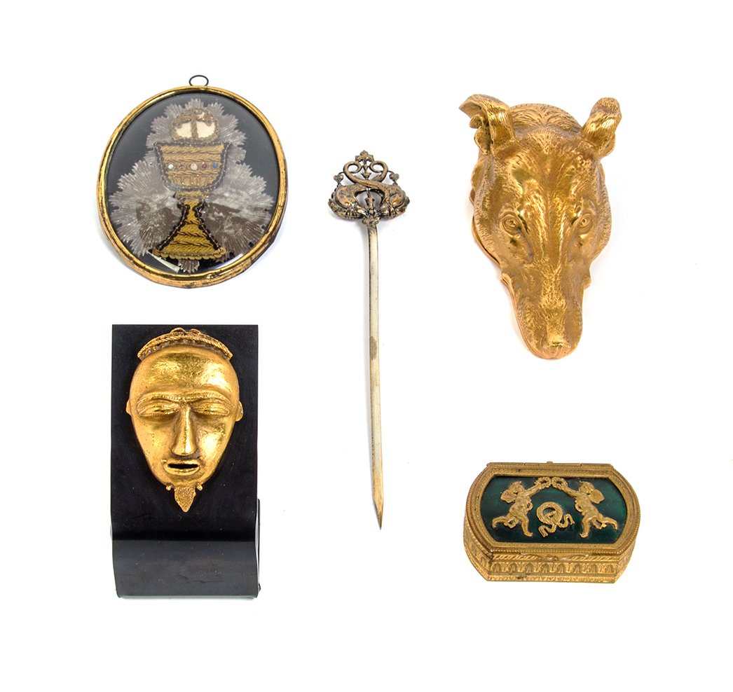 A Collection of Decorative Table Articles, Length of: A Collection of Decorative Table Articles, comprising a brass dog head clip, a gilt African mask, a carved horn tumbler, a skewer and an embroidered chalice. Length of first 6 3/4 inches.