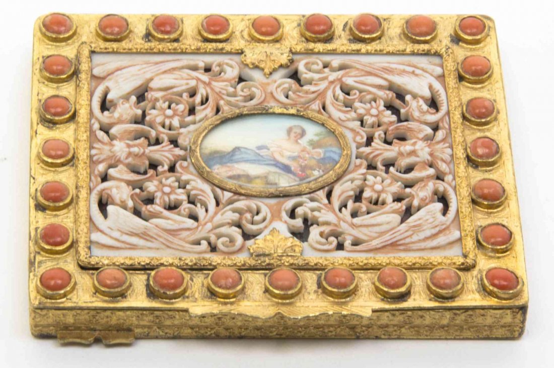 An Italian Gilt Metal and Jeweled Compact, Width 3 1/2: An Italian Gilt Metal and Jeweled Compact, of rectangular form with a hinged lid, centered with a miniature painting of a reclining woman, opening to a mirrored interior. Width 3 1/2 inches.
