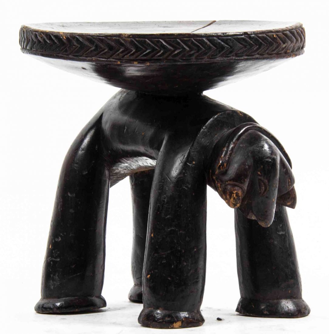 An African Carved Wood Stool, Height 9 1/2 inches.: An African Carved Wood Stool, having a circular seat raised on the back of a stylized animal. Height 9 1/2 inches.