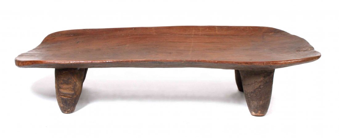 An African Carved Wood Senufo Bed, Height 14 3/4 x: An African Carved Wood Senufo Bed, having a shaped rectangular top over four tapering squat legs. Height 14 3/4 x width 24 1/2 x depth 65 1/2 inches. Property from the Estate of Judith Wright, Sheboyg
