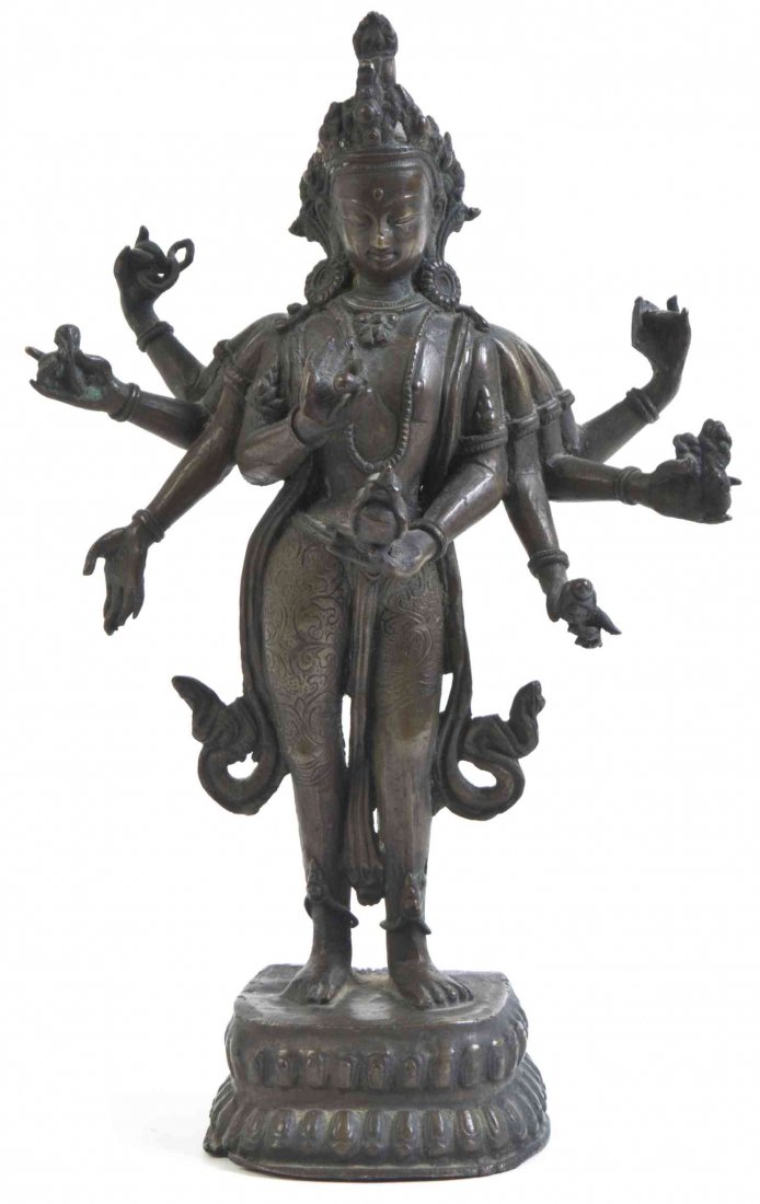 A Tibetan Bronze Figure of a Buddhist Deity Height 9: A Tibetan Bronze Figure of a Buddhist Deity the figure having eight arms bearing attributes, raised on a double lotus form base. Height 9 3/4 inches.