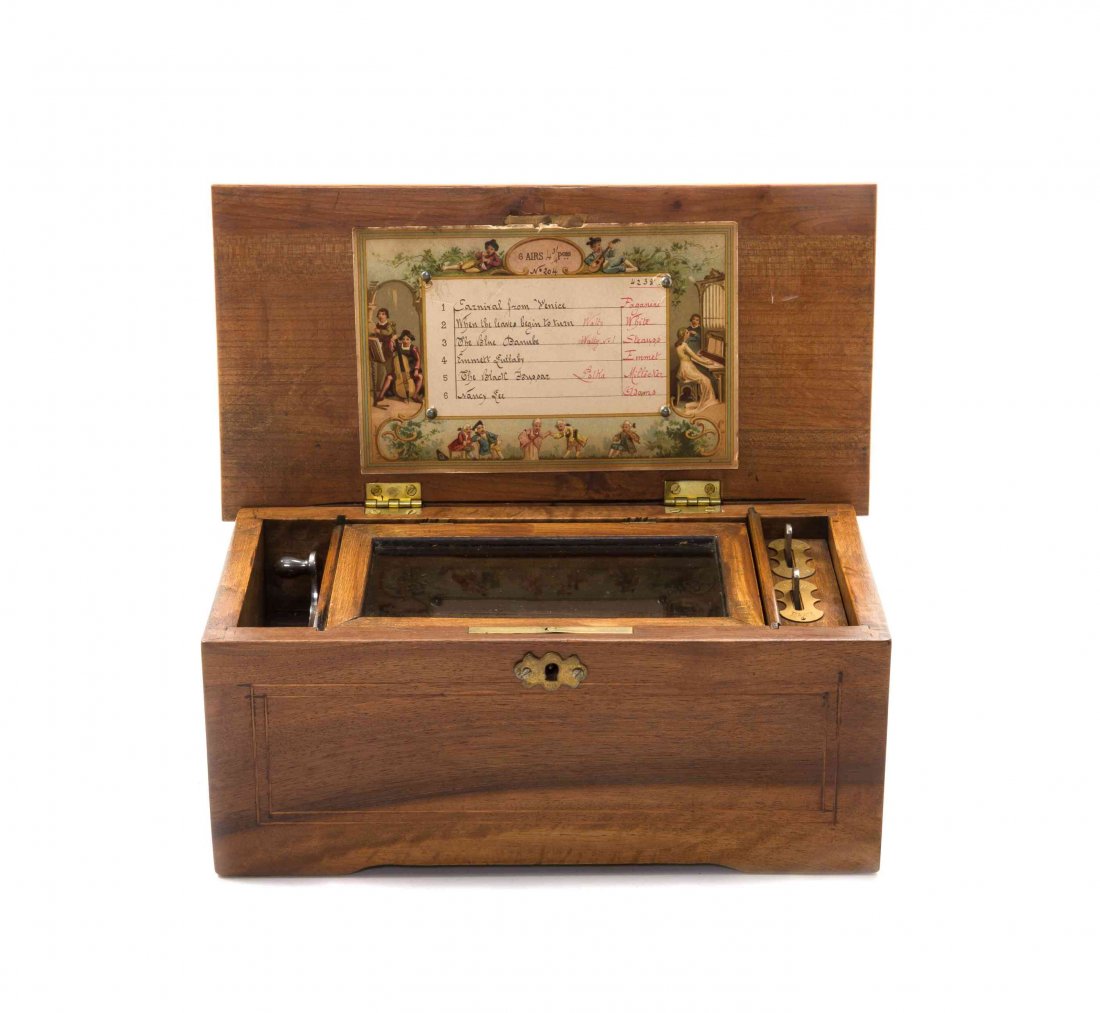 An Italian Walnut Cylinder Music Box Height 5 1/8 x: An Italian Walnut Cylinder Music Box the case with line inlays, playing six airs on one comb and a 4 1/4 inch cylinder. Height 5 1/8 x width 11 3/4 x depth 6 1/8 inches. Property from the Estate of Pa