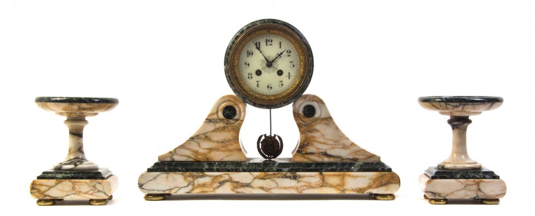 A Continental Marble Clock Garniture, LATE 19TH: A Continental Marble Clock Garniture LATE 19TH CENTURY comprising a clock and a pair of tazze, the clock having a circular dial with Arabic numerals over twin supports, raised on a plinth base set on 