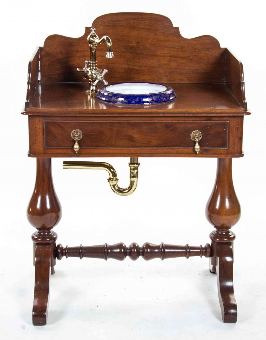 A Victorian Mahogany Washstand Height 41 x width 30 x: A Victorian Mahogany Washstand having a rectangular top with a three-quarter gallery, over a faux drawer set with a brass spicket and an English ceramic basin above the false drawer raised on twin sup