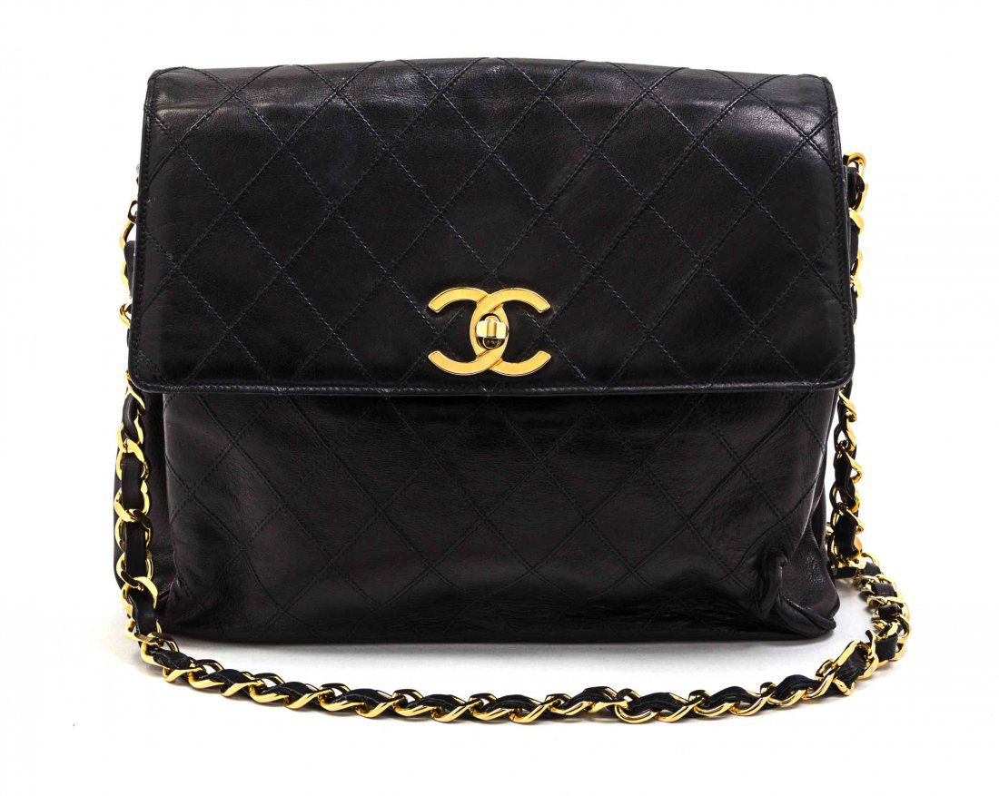 A Chanel Black Quilted Leather Flap Bag, 10 1/2 x 8 1/2: A Chanel Black Quilted Leather Flap Bag, interlocking 'C' logo clasp, gold hardware, interwoven leather and chain link shoulder strap, slip pocket, divided interior with zippered pocket. Stamped: Chan