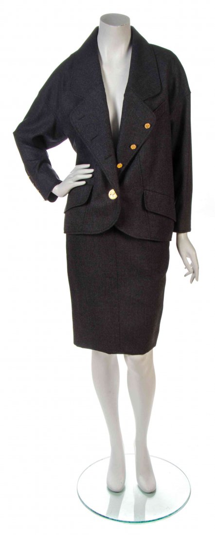 A Chanel Charcoal Grey Wool Skirt Suit,: A Chanel Charcoal Grey Wool Skirt Suit, comprised of single breasted jacket with goldtone Chanel profile buttons and two flap pockets, together with a fitted skirt with a yoke to the waist and center 