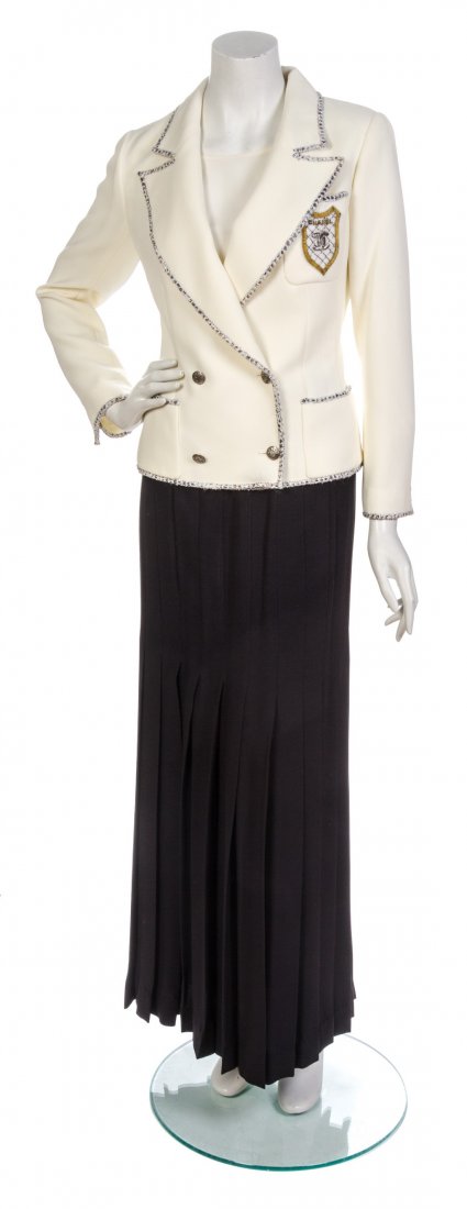 A Chanel Ivory Wool Crepe Crest Jacket,: A Chanel Ivory Wool Crepe Crest Jacket, double breasted, edged in a grey lurex tweed trim, with silvertone Chanel logo buttons, a single patch pocket to the breast with a Chanel crest patch and a silv