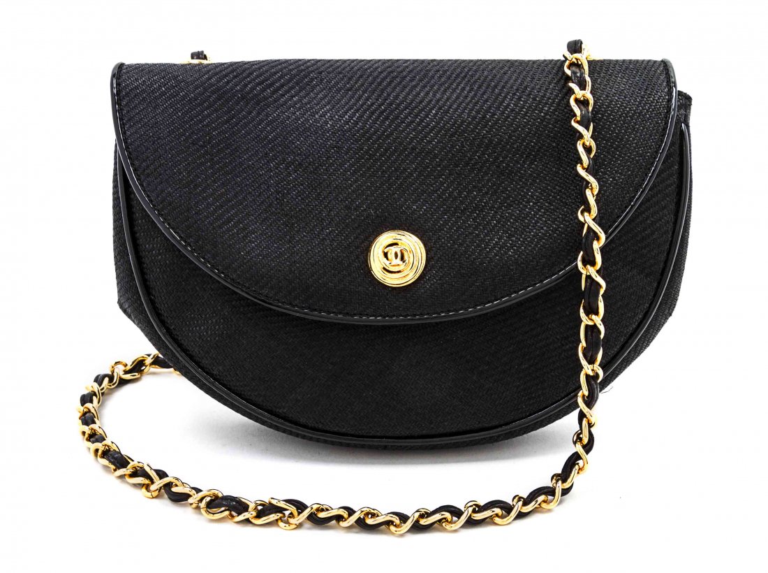 A Chanel Black Woven Straw Flap Bag, 8 x 6 x 2 inches.: A Chanel Black Woven Straw Flap Bag, circa 1987, with a goldtone interlocking 'C' button closure, interwoven leather and chain link shoulder strap, patent leather trim, leather lining, interior zipper