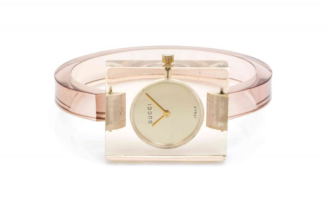 A Gucci Lucite Watch,: A Gucci Lucite Watch, 1970s, in brown lucite, with snap closure, circular dial in rectangular base. Stamped: Gucci.