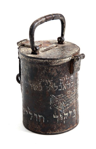 Charity Box – Bikur Holim Society: Charity box. [Unknown origin, early 19th cent.]. Cast iron, soldered and engraved. Conic box, with an opening lid with a carrying handle and a slot for inserting coins. Buckle and loop for lock. An il
