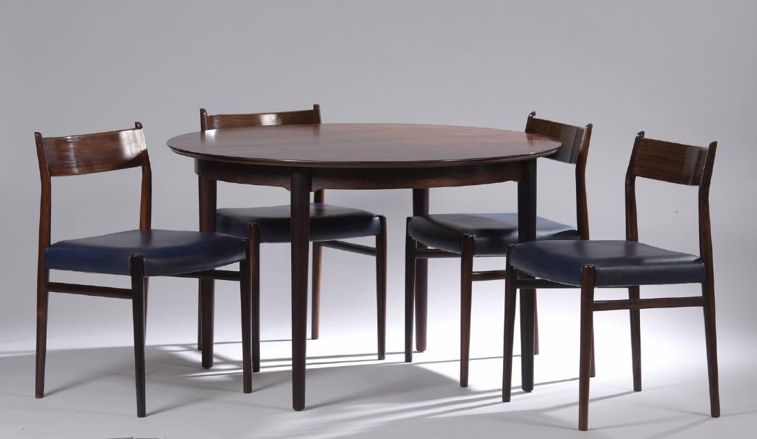 ARNE VODDER (1926-2009): ARNE VODDER (1926-2009).Modèle 204Table et une rallonge en bois de palissandre et 4 chaises modèle 418 , garniture d’origine en cuir bleu. Ed. Sibast . H.74 cm L.190 cm P.115 cm .Diam (sans rallon