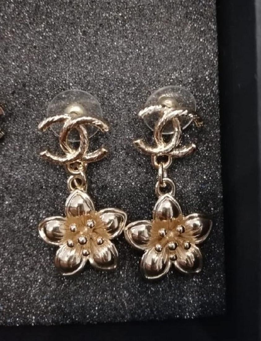 CHANEL -EARRINGS: CHANELPAIRE DE BOUCLES D'OREILLE en métal doré figurant une fleur. Signé. Dans leur boîte d'origine. Parfait état.